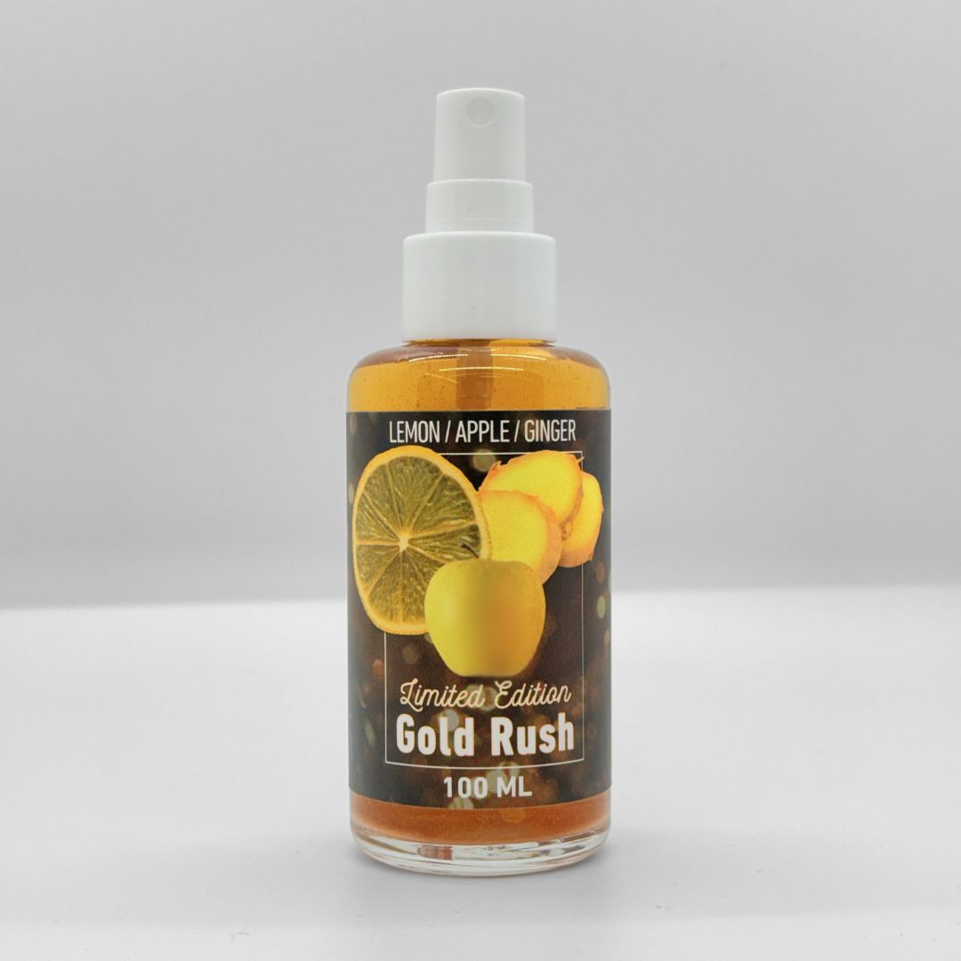 A bottle of Gold Rush deodorant with a label showing lemon, apple, ginger, and a cinnamon stick. The text indicates it is a limited edition with bright, fresh, sweet notes and 100 ml volume.